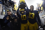 Michigan linebacker Devin Bush (10) and defensive end Lawrence Marshall (93) carry the Little Brown Jug to the locker room after Michigan beat Minnesota, 33-10, at Michigan Stadium on Saturday, November 4, 2017. MLive file photo.
