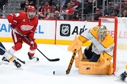 Nashville Predators goaltender Juuse Saros (74) stops a shot as Detroit Red Wings center Tyler Motte (14) looks for a rebound in the second period of an NHL hockey game Saturday, Oct. 12, 2024, in Detroit. (AP Photo/Paul Sancya)