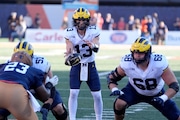 Michigan quarterback Jack Tuttle takes the snap from center in the shotgun formation during the first half of an NCAA college football game against Illinois on Saturday, Oct. 19, 2024, in Champaign, Ill.