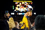 Michigan players carry out the Paul Bunyan trophy after winning the game on Saturday, Oct. 29, 2022 in Ann Arbor. Michigan defeated Michigan State 29-7. (Kaytie Boomer | MLive.com) 