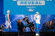 From left, Detroit Lions tight end Sam LaPorta (87), Detroit Lions safety Kerby Joseph (31) and Detroit Lions defensive tackle Alim McNeill (54) pose in a Honolulu Blue and silver uniform with white lettering, black uniform with Honolulu Blue lettering and silver trim and white uniform with Honolulu Blue lettering during an unveiling ceremony for new Detroit Lions uniforms at Ford Field in Detroit on Thursday, April 18, 2024.