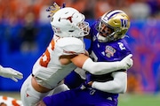 Texas defensive back Michael Taaffe (16) tackles Washington wide receiver Ja'Lynn Polk (2) during the Sugar Bowl CFP NCAA semifinal college football game, Monday, Jan. 1, 2024, in New Orleans. (AP Photo/Jacob Kupferman)