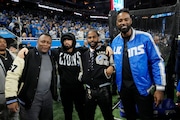 From left, former Detroit Lions running back Barry Sanders stands with musicians Eminem and Big Sean and former receiver Calvin Johnson during pregame of an NFL wild-card playoff football game against the Los Angeles Rams, Sunday, Jan. 14, 2024, in Detroit. (AP Photo/Paul Sancya)