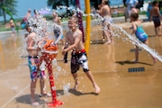 Kids spray one another with water cannons at the splash park inside Bay City State Park.