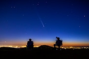 Comet Tsuchinshan-Atlas makes an appearance in the western night sky as amateur photographers Nolan Letellier, left, and Link Jackson observe on a ridge near the Dry Creek Trailhead in Boise, Idaho. Monday, Oct. 14, 2024 (AP Photo/Kyle Green)
