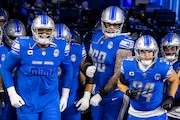 Detroit Lions offensive tackle Penei Sewell (58), offensive tackle Taylor Decker (68) and linebacker Alex Anzalone (34) take the field before the NFL divisional round playoff game against the Tampa Bay Buccaneers at Ford Field in Detroit on Sunday, Jan. 21, 2024. 