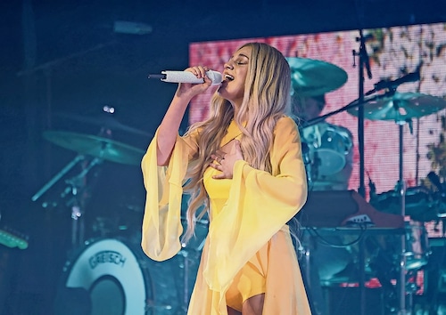 Kelsea Ballerini singing in a yellow outfit