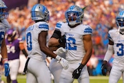 Detroit Lions safety Brian Branch (32) reacts to his interception with Terrion Arnold (0) during the first half of an NFL football game against the Minnesota Vikings Sunday, Oct. 20, 2024, in Minneapolis. (AP Photo/Bruce Kluckhohn)