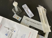 The contents of an at-home rapid test provided by the federal government and distributed nation-wide by the U.S. Postal Service sits on a table in southern Michigan.