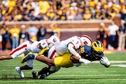 Michigan Wolverines running back Kalel Mullings (20) runs with the ball, tackled. By Arkansas State Red Wolves linebacker Marvin Ham (5) and Arkansas State Red Wolves safety Dontay Joyner (6) during Michigan vs Arkansas State Football game at Michigan Stadium in Ann Arbor on Saturday, Sept. 14, 2024. 