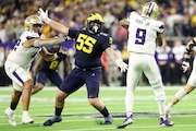 Michigan defensive lineman Mason Graham (55) pressures Washington quarterback Michael Penix Jr. (9) during the national championship at NRG Stadium in Houston on Monday, Jan. 8, 2024.