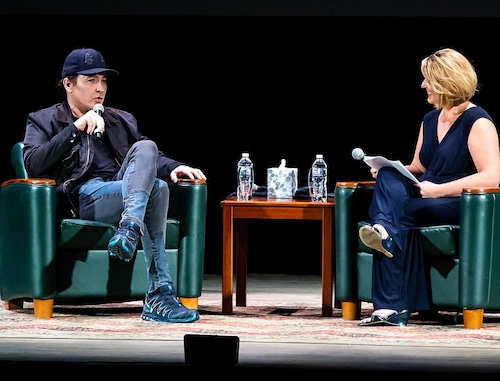 john cusack talking to a woman on stage