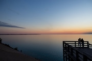 People take in sunset from the observation deck at the Lake Michigan overlook along the Pierce Stocking Scenic Drive at Sleeping Bear Dunes National Lakeshore in Empire, Mich. on Thursday, Oct. 3, 2024.  